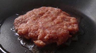 Close-up of a patty being prepared in a frying pan with butter. Homemade food. Burger patty