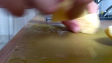 The girl cuts potatoes with a knife for cooking french fries. Preparing vegetables for cooking. Slicing vegetables