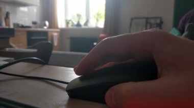 Close-up on a mouse and a human hand. A man works at a computer. Modern technologies. Home Office. Distant work