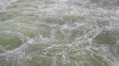 Large flow of water. Fast mountain river. Water background. Foam and splashes from the river flow