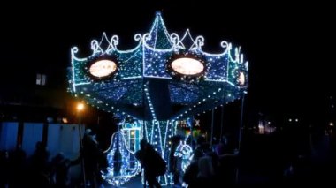 Warsaw, Poland, December 15, 2021: bright carousel for children and adults in the city in the evening. Christmas holidays, entertainment. New Year's eve, holiday