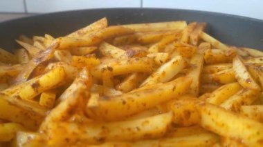 Close-up on yellow fried potatoes. Potatoes are cooked in a frying pan, homemade food