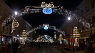 Warsaw, Poland, December 23, 2021: beautiful decorated streets in Warsaw in the old part of the city on the eve of Christmas and New Year. Tourists and locals walk along the beautiful streets