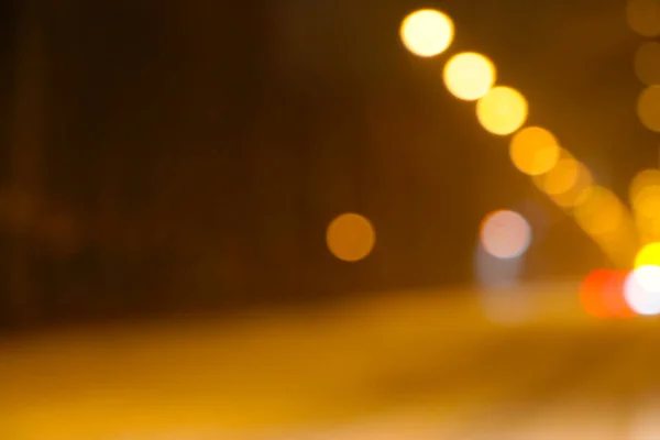 Blurred background of street lighting on a winter day. Moving car lights