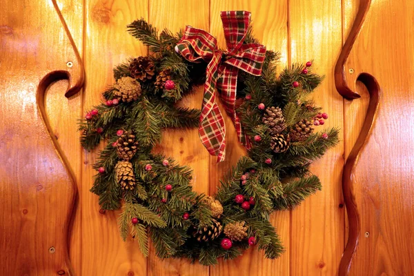A spruce Christmas wreath hangs on the door. Preparing for the New Year