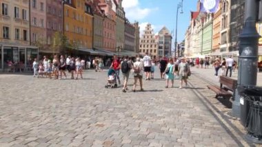 Wroclaw, Polonya, 14 Ağustos 2021: Turistler ve yerliler güneşli bir günde güzel caddelerde yürüyorlar
