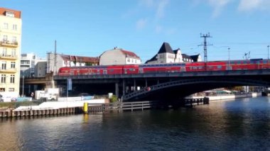 Berlin, Almanya, 1 Ekim 2022: Berlin 'deki Spree Nehri üzerinde bir tren hareket ediyor. Modern ve hızlı ulaşım