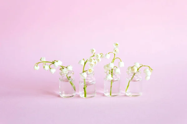 春花在白色的背景上,百合花在山谷中.在小玻璃瓶中绽放的百合花 — 图库照片