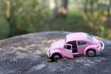 Oyuncak pembe araba. Araba sigortası konsepti ve araba kazası oyuncağı.