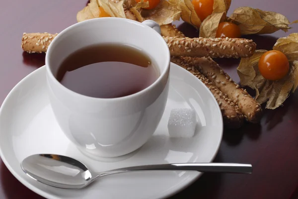 Black tea and cookies with physalis — Stock Photo, Image