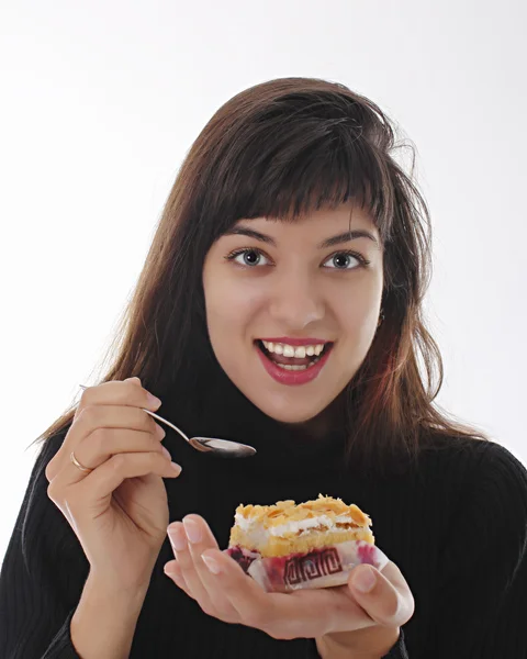 Jovem sorrindo menina comendo uma fatia de bolo — Fotografia de Stock