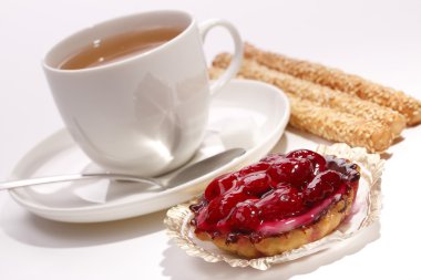 bir fincan çay ve bisküvi ile frambuazlı pasta