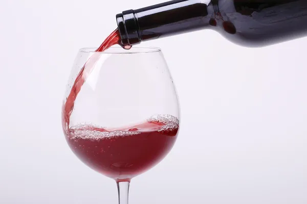 Junger Rotwein wird in ein Glas gegossen — Stockfoto