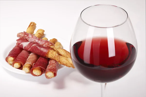 Copo de vinho tinto e biscoitos com bacon — Fotografia de Stock