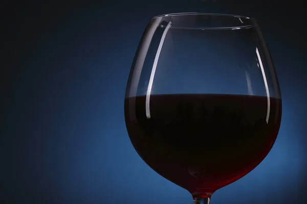 Verre à vin rouge sur fond bleu — Photo