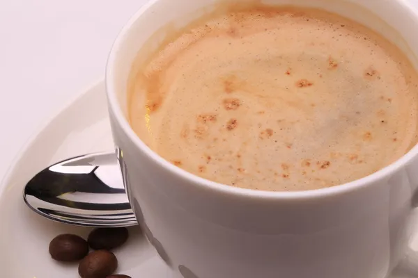 Copa de capuchino y granos de café — Foto de Stock