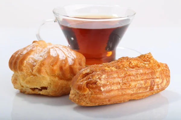 Tea with eclair and profiterole — Stock Photo, Image