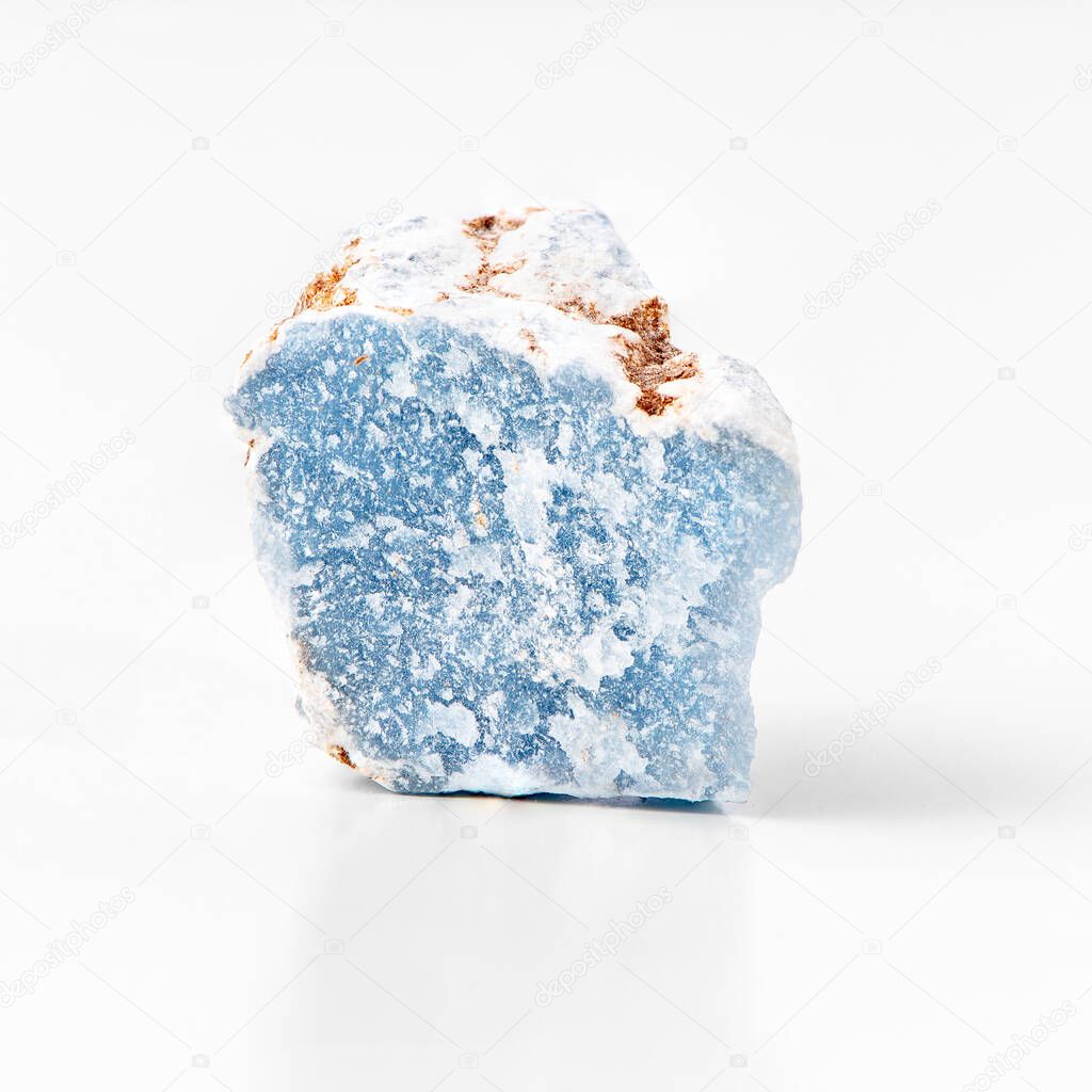 Blue calcium sulfate mineral rock isolated on white background. Angelite rough mineral stone of light blue color. 