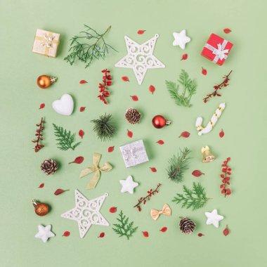 Renkli, düz bir Noel deseni. Küçük süsler, yeşiller, yapraklar, çamlar ve kare şeklinde hediyeler. Parlak yeni yıl geçmişi, kış sezonu hediye kartı.