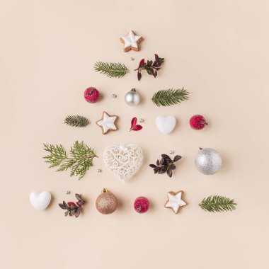 Küçük süslemelerden ve açık sarı arka planda yeşillikten yapılmış şirin bir Noel ağacı. Minimum tatil kartı tasarımı, düz uzanma. 