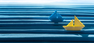 Küçük kağıt tekneler ve mavi kumaştan yapılmış yaz denizi. Tatil ve seyahat kavramı. 