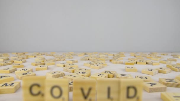 Covid Palavra Letras Scrabble Letras Raspadas Espalhadas Uma Mesa Branca — Vídeo de Stock