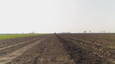 Ekin tarlası yere yakın boş bir kamera. Traktör lastik izleri yerde. Toprak sürüldü.