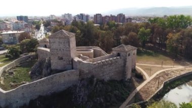 Sırbistan 'ın Pirot kentinde küçük bir ortaçağ kalesi. Taş duvarlar. Arka planda kasaba. Hava aracı görüntüsü, yörüngede dönen kamera. Parlak güneşli bir gün. 5