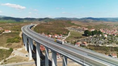 Viyadük köprüsü, düşük trafik, kamyon geçiyor. Hava aracı güneşli bir günde vuruldu. Güney Sırbistan 'daki viyadük köprüsünde trafik düşük. Birkaç araba ve bir kamyon geçiyor. Hava aracı atışı. Skyline, tepeler. Parlak güneşli bir gün.