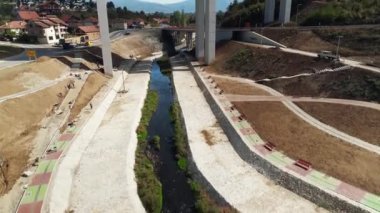 Otoyol trafiği yok, kamera yukarı yükseliyor ve arkadaki küçük kasabayı gösteriyor. Güneşli bir gün. Hava aracı görüntüsü.