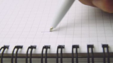 Ball point pen biro writing Dear Mom.Hand writing Dear Mom on checkered paper. Macro shot. Starting a letter.