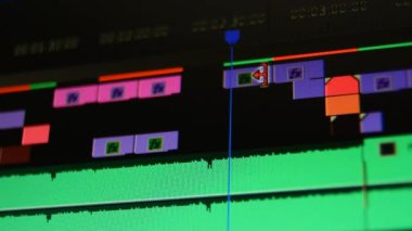 Görüntü düzenleme yazılımı yüksek kontrastlı. Video düzenleme yazılımındaki bilgisayar ekranının Dolly görüntüsü. Film müziği kliplerinin yerini değiştiriyorum. Alçak alan derinliği.