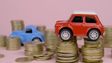 Cars among coins, one car on top of pile of coins. Stacks of coins around it.Car costs piling up. Expenses - repair, insurance, fuel. Pink background. Everything costs money. Modern cars getting more and more expensive.