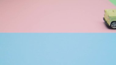 Four toy cars CLOSE on differet colored surfaces.Camera slides revealing four toy cars standing on different colored surfaces. Lots of copy space for your important messages.