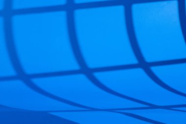 Güzel pencere ışığı ve gölgeli ürün sunumu için mavi arkaplan