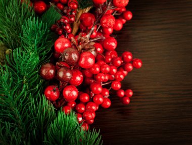 Kırmızı böğürtlenlerden, kürk ağacından ve konilerden Noel çelengi