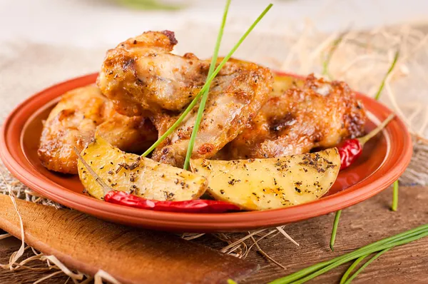 Fried chicken wings with baked potatoes — Stock Photo, Image