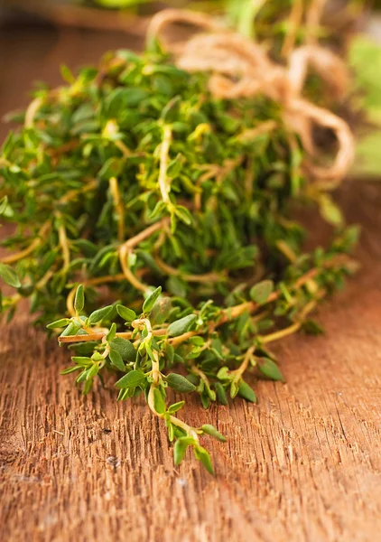 Tijm bos met een ruwe touw op een houten bord — Stockfoto