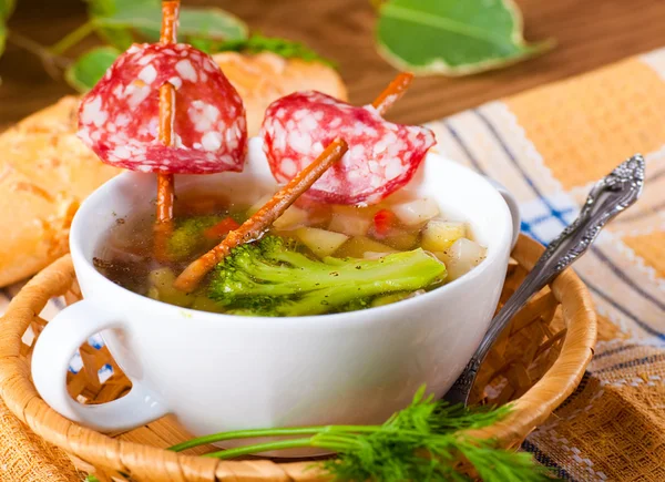 Vegetable soup with salty straws and raw smoked sausage — Stock Photo, Image