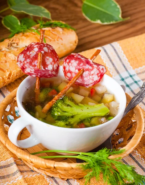 Vegetable soup with salty straws and raw smoked sausage — Stock Photo, Image