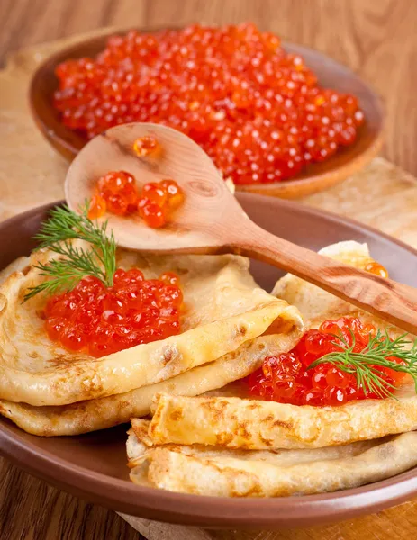Pancakes with red caviar on wooden ware — Stock Photo, Image