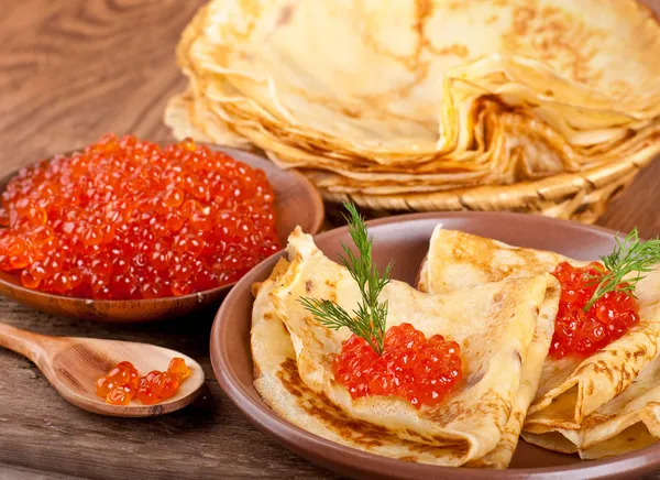 Panqueques con caviar rojo sobre vajilla de madera — Foto de Stock