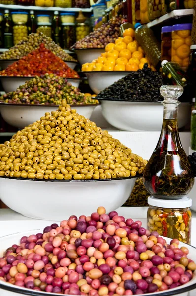 It is a lot of multi-colored olives and olive oil in the market Stock Image