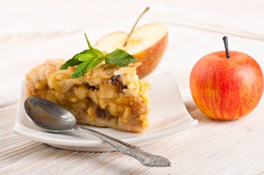 ahşap bir masa üzerine elmalı turta ve taze elma