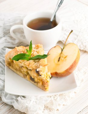 ahşap bir masa üzerine elmalı turta ve taze elma