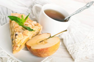 ahşap bir masa üzerine elmalı turta ve taze elma