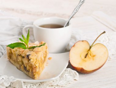 ahşap bir masa üzerine elmalı turta ve taze elma