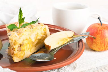 ahşap bir masa üzerine elmalı turta ve taze elma