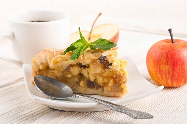 Apfelkuchen und frische Äpfel auf einem Holztisch — Stockfoto