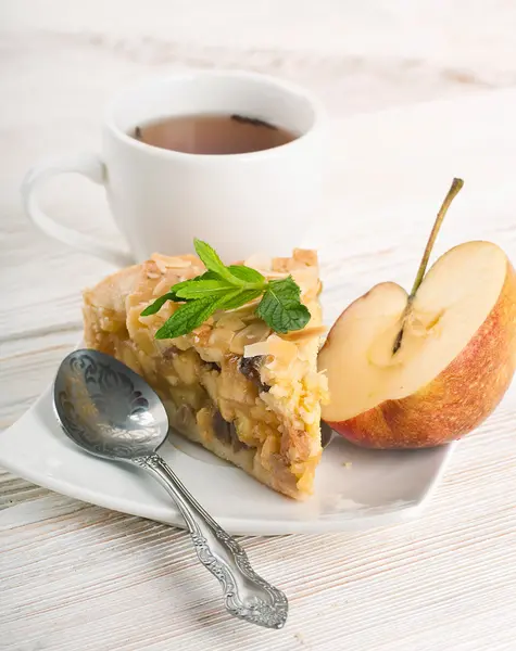 Apfelkuchen und frische Äpfel auf einem Holztisch — Stockfoto